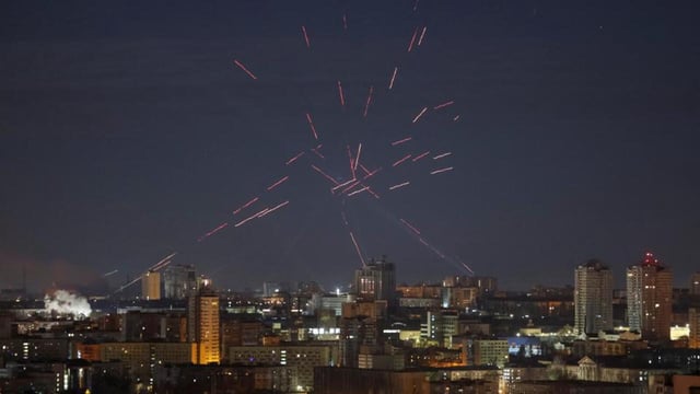 A flying Russian drone, tracers and searchlights are seen in the night sky as Ukrainian servicemen search for drones and fire at them during a Russian drone strike, amid Russia's attack on Ukraine, in Kyiv, on April 12 (REUTERS)