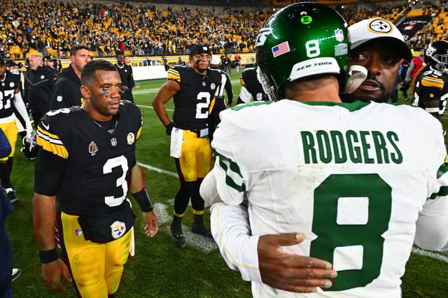 PITTSBURGH, PENNSYLVANIA - OCTOBER 20: Russell Wilson #3 and Justin Fields #2 of the Pittsburgh Steelers look on as head coach Mike Tomlin of the Pittsburgh Steelers and Aaron Rodgers #8 of the New York Jets embrace after the game at Acrisure Stadium on October 20, 2024 in Pittsburgh, Pennsylvania.