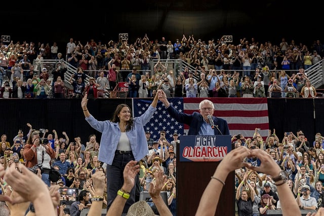 U.S. Rep. Alexandria Ocasio-Cortez (D-NY) and U.S. Sen. Bernie Sanders (I-VT) speak to a full auditorium as part of the "Fighting Oligarchy" tour on April 14, 2025 in Nampa, Idaho. According to event organizers, 12,500 people attended the rally. 