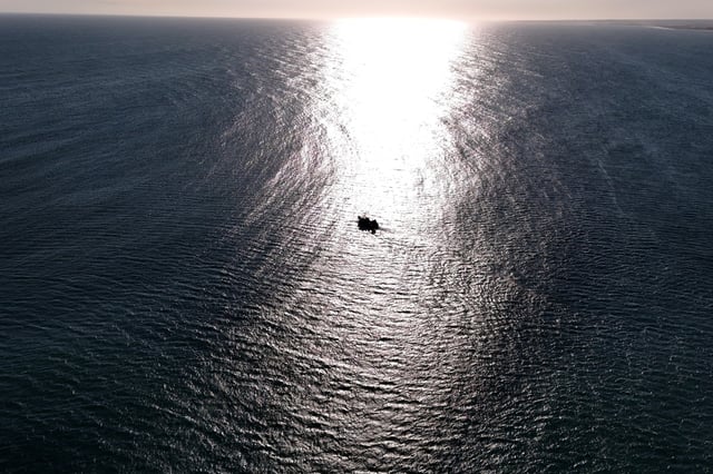 A drone view shows a commercial fishing boat leaving the port, as cuts by U.S. President Donald Trump's administration to NOAA (National Oceanographic and Atmospheric Administration) imperil key fishing data and research, in Point Judith, Rhode Island, U.S., March 13, 2025. REUTERS/Brian Snyder/File Photo