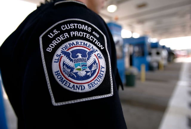 U.S. Customs and Border Protection officer checks a tractor-trailer for clearance after crossing from Canada on September 20, 2005, in New York.