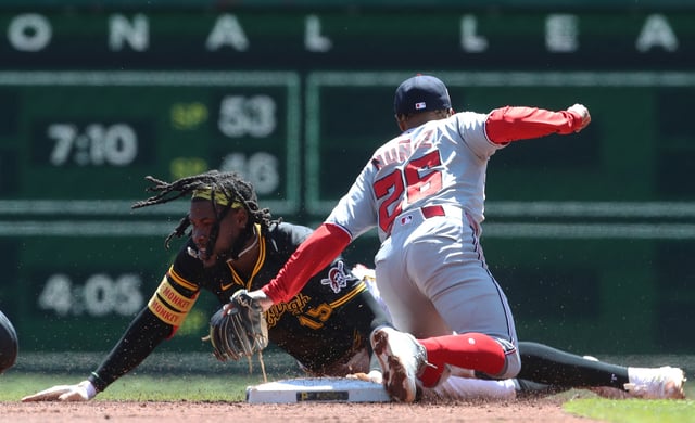 Apr 17, 2025; Pittsburgh, Pennsylvania, USA;  Pittsburgh Pirates center fielder Oneil Cruz (15) steals second base ahead of a tag attempt by Washington Nationals shortstop Nasim Nunez (26) during the third inning at PNC Park. Mandatory Credit: Charles LeClaire-Imagn Images