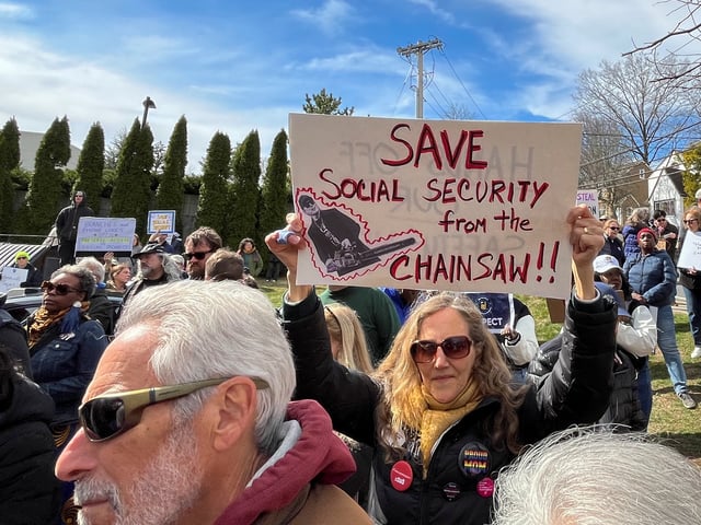 A woman holds a sign during a protest against cuts made by U.S. President Donald Trump's administration to the Social Security Administration, in White Plains, New York, U.S., March 22, 2025. REUTERS/Nathan Layne/File Photo