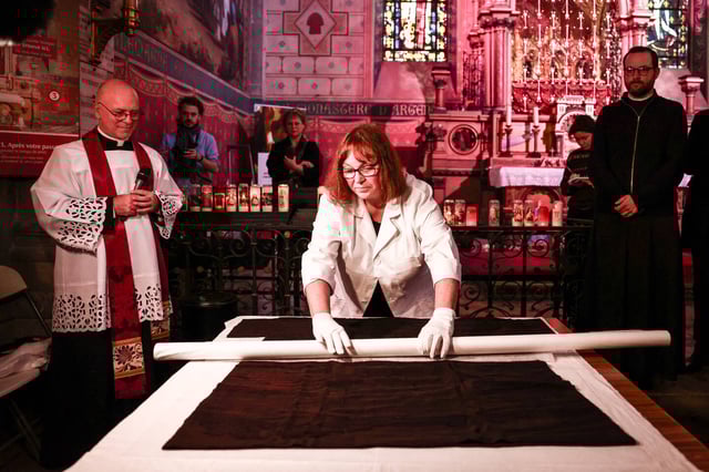 La restauratrice française Claire Beugnot (au centre) déballe la Sainte Tunique, à Argenteuil, le mercredi 16 avril 2025.
