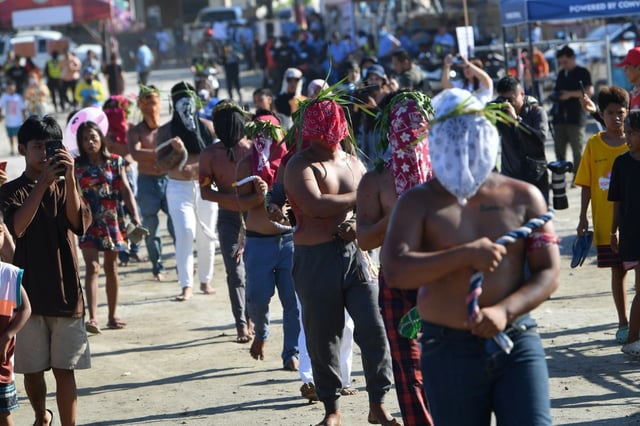 Penitents cover their faceds with bandanas and whip themselves with bamboo-tipped flails as an act of penitence