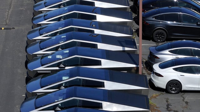 In an aerial view, brand new Tesla Cybertrucks sit parked in a lot at a Tesla dealership on April 02, 2025 in Corte Madera, California.