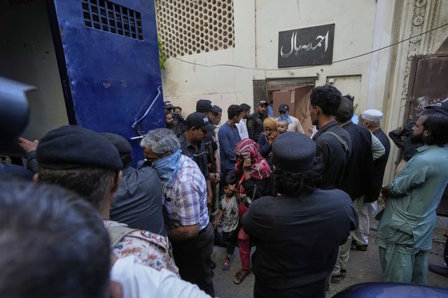 Police officers rescue members of Pakistan's minority Ahmadi community from their place of worship, where supporters of Tehreek-e-Labbaik Pakistan or TLP party hold a demonstration against the Ahmadi, in Karachi, Pakistan, Friday, April 18, 2025. (AP P hoto/Fareed Khan)