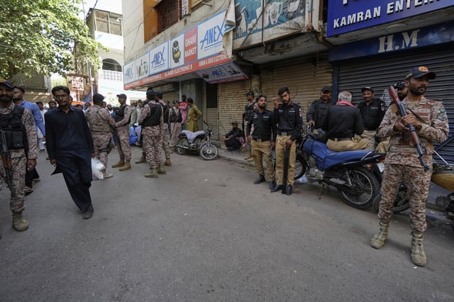 Paramilitary soldiers and police officers stand guard at outside the Pakistan's minority Ahmadi community's place of worship, where supporters of Tehreek-e-Labbaik Pakistan or TLP party hold a demonstration against the Ahmadi, in Karachi, Pakistan, Friday, April 18, 2025. (AP P hoto/Fareed Khan)