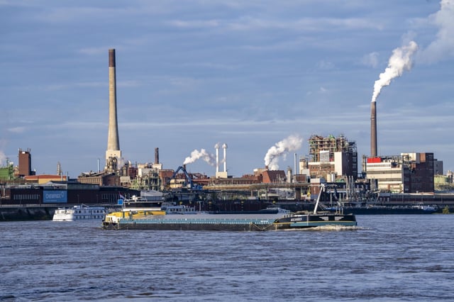 Chempark Krefeld-Uerdingen, rund 40 Betriebe sind in dem Chemiepark am Rhein angesiedelt, es gibt 3 Chemparks in NRW, Frachtschiff auf dem Rhein, Deutschland. Unternehmen bleiben skeptisch.
