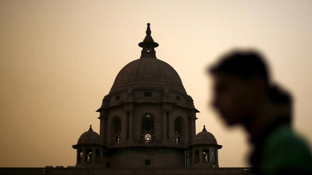 FILE PHOTO: A commuter walks past the building of India's Ministry of Finance during dusk in New Delhi (REUTERS)