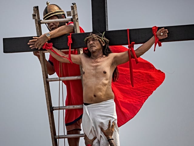 SAN FERNANDO, PHILIPPINES - APRIL 07: Penitent Ruben Enaje is removed from a cross after he was crucified during Good Friday crucifixions on April 07, 2023 in San Fernando, Pampanga, Philippines. Holy Week is a Christian observance that commemorates the passion, death, and resurrection of Jesus Christ, typically observed during the week leading up to Easter Sunday. As Asia's most Catholic nation, Holy Week is observed in the Philippines as a significant religious holiday with various customs and traditions. Crucifixions have been allowed on Good Friday for the first time since the pandemic. The practice involves penitents being voluntarily nailed to a cross as a form of penance, but it is seen as extreme and is strongly discouraged by the Catholic church. (Photo by Ezra Acayan/Getty Images)