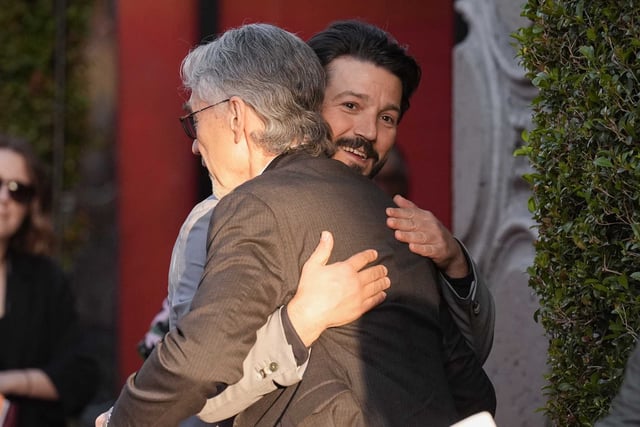 Tony Gilroy, left, and Diego Luna embrace at a launch event of the second season of “Andor” on April 14, 2025, at the El Capitan Theatre in Los Angeles.