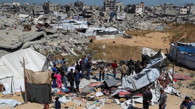 Menschen versammeln sich einem Ort im Gazastreifen, an dem eine Familie bei einem israelischen Angriff angeblich ums Leben gekommen sein soll.