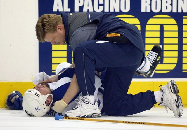 Toronto Maple Leafs right-winger Darcy Tucker is attended to by Leafs athletic therapist Chris Broadhurst late in third period of NHL Eastern Conference semifinal action in Toronto on Friday May 10, 2002. Tucker was checked head first into the boards by Ottawa Senators' Daniel Alfredsson seconds before Alfredsson scored the game winning goal. (CP PHOTO/Frank Gunn)