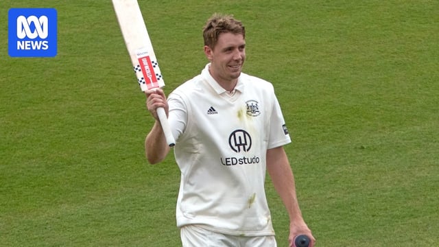 Cam Green raises his bat with his right hand