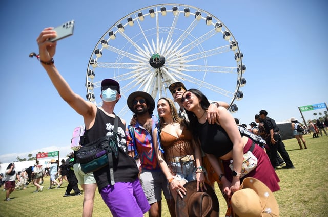 Festival-goers pose for a photo in front of the Ferris wheel during the Coachella Valley Music and Arts Festival in Indio on Friday, April 18, 2025.(Photo by Andy Holzman, Contributing Photographer)