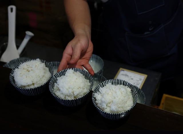Arata Hirano prepares bowls of cooked California-grown Calrose rice to serve to customers at his restaurant Shokudou Arata in Tokyo, Japan, April 14, 2025. REUTERS/Kim Kyung-Hoon/File Photo