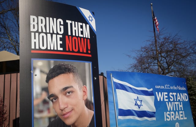 Signs and a photograph of Edan Alexander, the American-Israeli and Israel Defense Forces soldier taken hostage during the October 7, 2023 attack on Israel by Hamas, stand outside a Jewish community center in Alexander’s home town of Tenafly, New Jersey, U.S., December 14, 2024. REUTERS/Stephani Spindel/File Photo