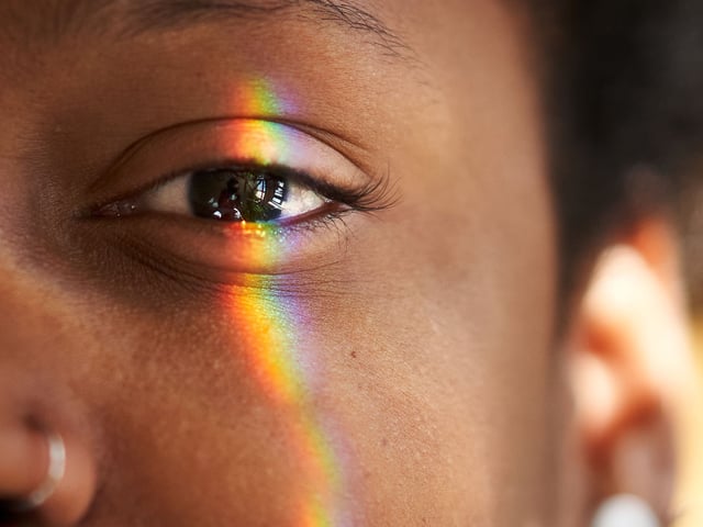 A closeup of an eye with a rainbow.