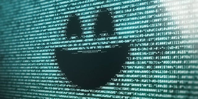 A smiley face on an electronic screen with data scrolling behind in Black Mirror Season 7.