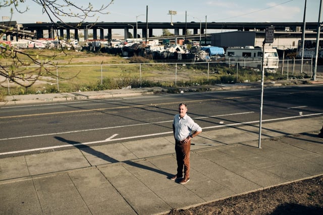 Land use attorney Robert Selna stands for a portrait outside a fenced off space across the West Oakland Bart station that was originally scheduled for housing construction in Oakland, California, on Wednesday, April 9, 2025. Selna is fighting against the use of CEQA, an environmental law that allows lawsuits to be brought against project development, preventing the state from building new housing. (Don Feria for Bay Area News Group)