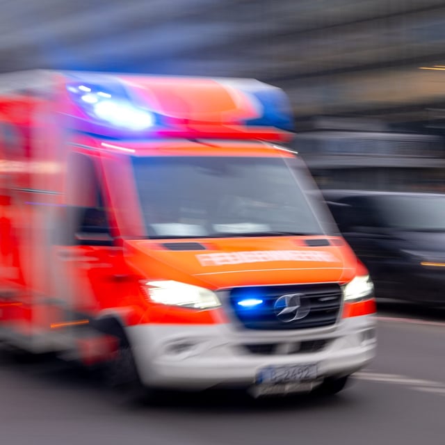 Ein Rettungswagen der Feuerwehr fährt mit Blaulicht zum Einsatz. In Dresden ist ein Mann in einen metertiefen Schacht gestürzt. (Symbolbild)