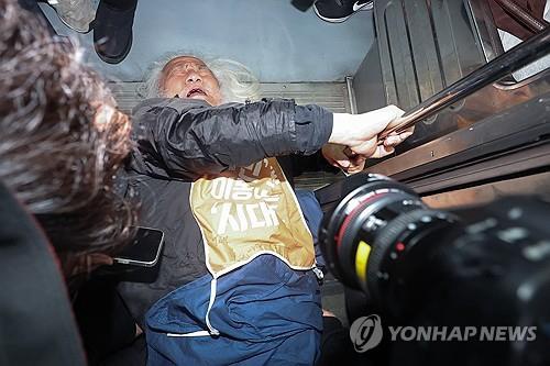 Park Kyoung-seok, the leader of the Solidarity Against Disability Discrimination, lies at the entrance of a subway train after clashing with Seoul Metro officials during a subway-riding protest at Hyehwa Station in Seoul on April 21, 2025. (Yonhap)