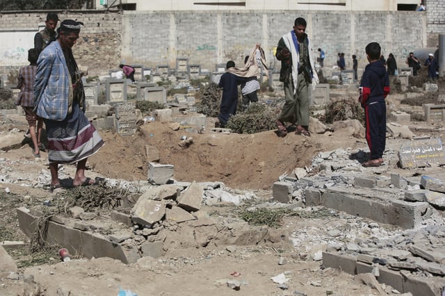 Yemenis watch a hole at Magel Al-Dammah cemetery a day after it was struck by U.S. airstrikes in Sanaa, Yemen, Sunday, April 20, 2025. (AP Photo)