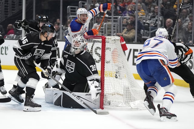 Edmonton Oilers center Connor McDavid, right, celebrates his goal with left wing Zach Hyman, second from right, as Los Angeles Kings goaltender Cam Talbot, center, kneels in goal while defenseman Vladislav Gavrikov, left, and center Blake Lizotte watch during Game 3 of an NHL hockey Stanley Cup first-round playoff series Friday, April 26, 2024, in Los Angeles.