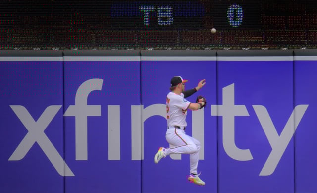 Baltimore Orioles right fielder Ryan O&#39;Hearn leaps as a drive from Cincinnati Reds batter TJ Friedl flies above him during an interleague game of major league baseball in front of 19,053 fans at Oriole Park at Camden Yards. (Karl Merton Ferron/Staff)