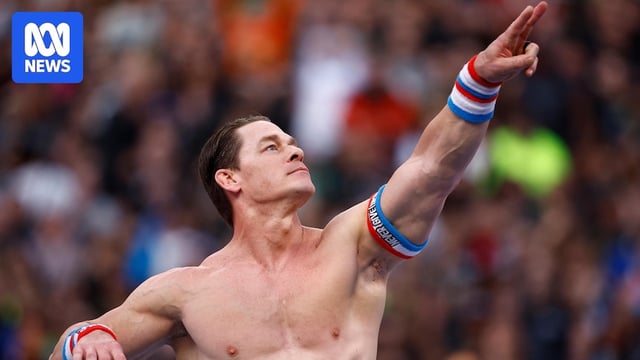 A shirtless man poses in a wrestling ring.