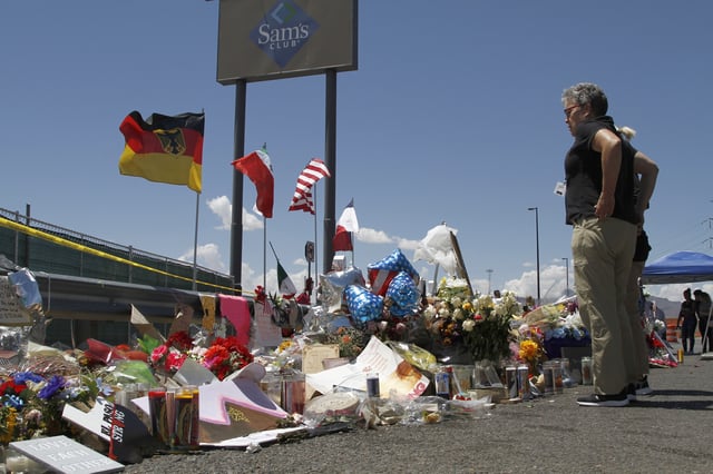 FILE - In this Aug. 12, 2019 photo, mourners visit the makeshift memorial near the Walmart in El Paso, Texas. (AP Photo/Cedar Attanasio, File)