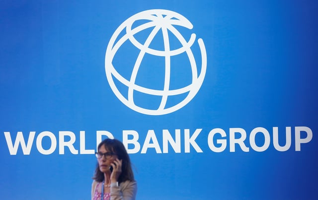 A participant stands near a logo of World Bank at the International Monetary Fund - World Bank Annual Meeting 2018 in Nusa Dua, Bali, Indonesia, October 12, 2018. REUTERS/Johannes P. Christo