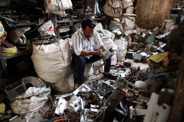 A man recycles electronic waste, or e-waste, from computer power supplies at a scrap yard in Ahmedabad, India, April 9, 2025.REUTERS/Amit Dave/File Photo