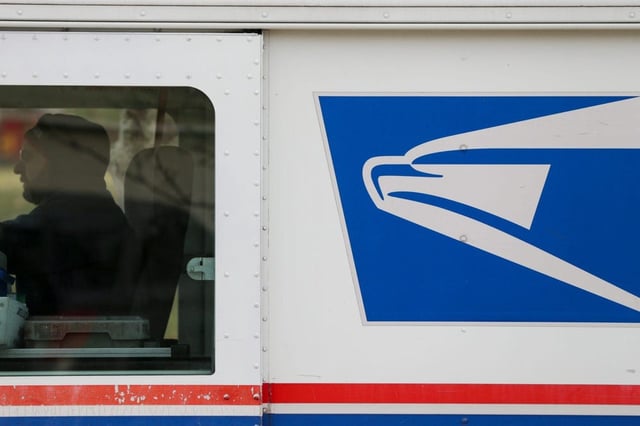 A postal worker delivers mail in the University Farms neighborhood of West Lafayette, Ind., on  Jan. 19, 2022.