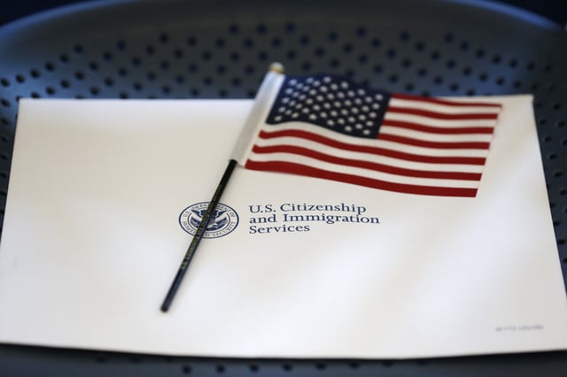 An information packet and an American flag are placed on a chair at the U.S. Citizenship and Immigration Services Miami Field Office, Friday, Aug. 17, 2018, in Miami.
