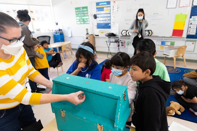 Kendal Sager, Sager Family Farm's executive director, opens up an observation bee hive for first grade students to peer into at The Primary School on Dec. 9, 2022. The organization received a $15,000 Holiday Fund grant to expand its nature-education programs into East Palo Alto. Photo by Magali Gauthier.