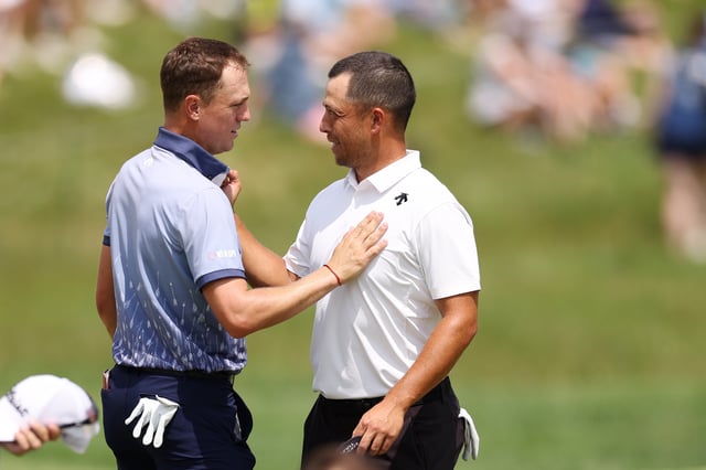 Justin Thomas of the United States congratulates Xander Schauffele of the United States on the ninth green during the first round of the 2024 PGA Championship at Valhalla Golf Club on May 16, 2024 in Louisville, Kentucky.