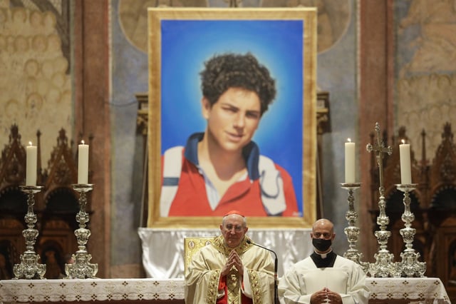 File Photo: A picture of 15-year-old Carlo Acutis, an Italian boy who died in 2006 of leukemia, is seen during his beatification ceremony celebrated by Cardinal Agostino Vallini, center, in the St. Francis Basilica, in Assisi, Italy, on October 10, 2020.