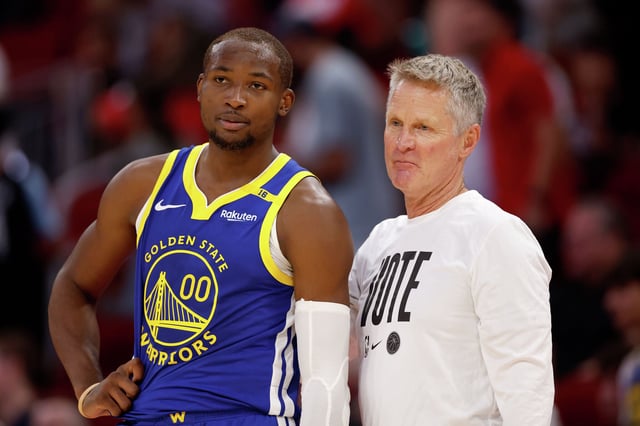 Jonathan Kuminga of the Golden State Warriors and head coach Steve Kerr stand on the sideline in overtime against the Houston Rockets at Toyota Center on Nov. 2, 2024, in Houston.