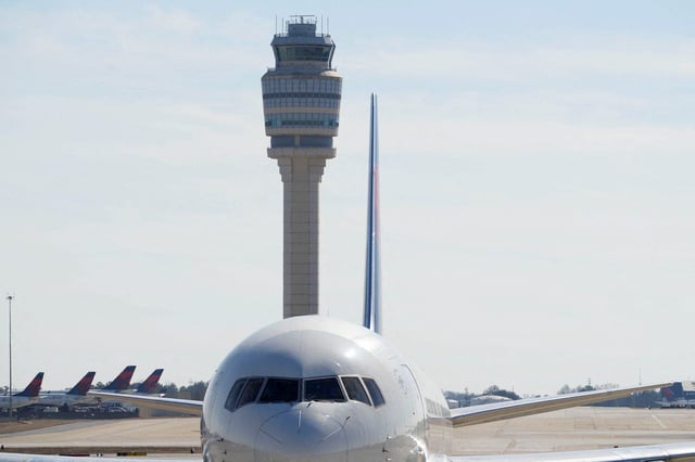 Atlanta's air traffic control tower is seen behind a plane at Hartsfield-Jackson Atlanta International Airport, in Georgia, U.S. February 1, 2025.  REUTERS/Megan Varner/File Photo