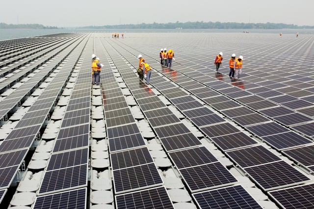 Workers walk between solar cell panels over the water surface of Sirindhorn Dam in Ubon Ratchathani, Thailand April 8, 2021. Picture taken April 8, 2021 with a drone. REUTERS/Prapan Chankaew