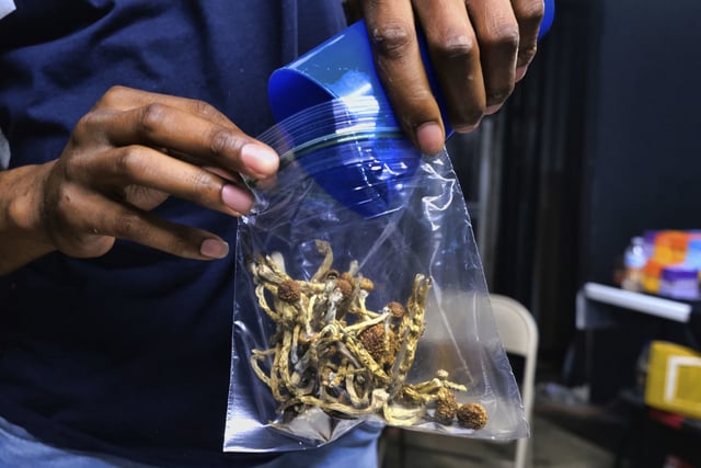A vendor bags psilocybin mushrooms at a cannabis marketplace in Los Angeles, on May 24, 2019.