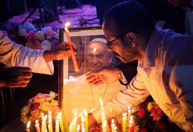 People light candles in front of a picture of Pope Francis, after his death was announced by the Vatican, during a condolence meeting in New Delhi, India, April 21, 2025.