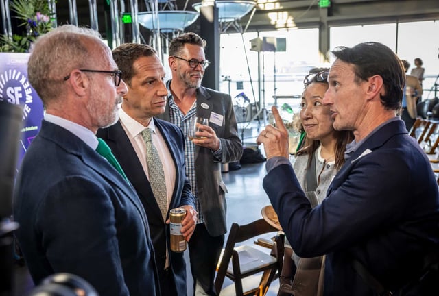 From left, Lindsay Bierman, executive director and CEO of the Exploratorium, and SF Mayor Daniel Lurie speak with Karen and Charles Oppenheimer (right) at the opening reception for San Francisco Climate Week at the Exploratorium in San Francisco, on Monday, April 21, 2025. The conference is one of the largest climate conferences in the country.