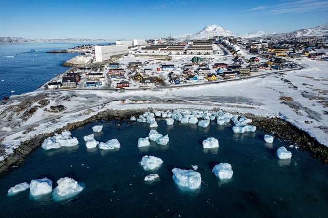 This aerial view shows icebergs floating in the waters beaten down by the sun with buildings in the background off Nuuk, Greenland, on March 11.