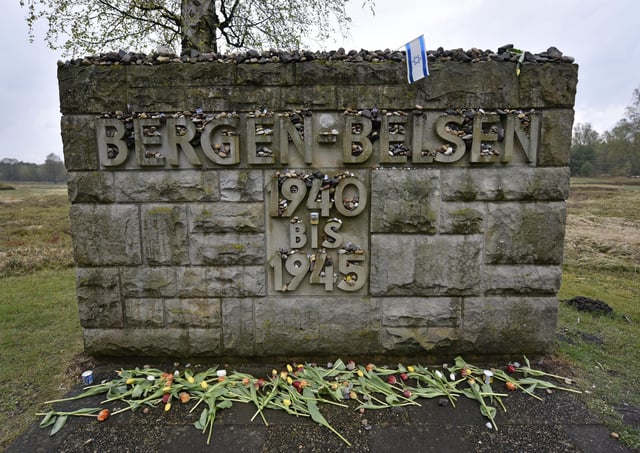 FILE — Flowers and stones are placed for the victims at a memorial stone at the Bergen-Belsen concentration camp in Bergen, northern Germany, April 26, 2015. (AP Photo/Martin Meissner, File)