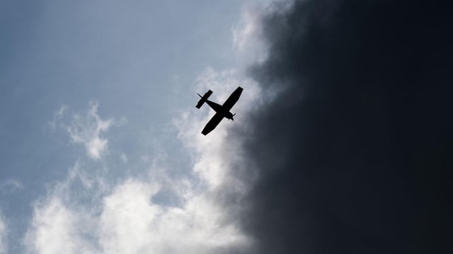 Ein Kleinflugzeug fliegt vor dunklen Wolken im Landkreis Hildesheim.