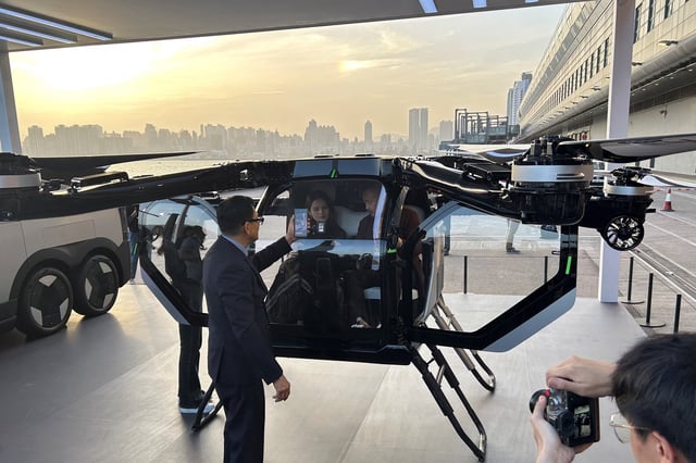 Chinese electric vehicle (EV) maker Xpeng displays a concept flying car, alongside a van designed to carry it, at a company event by the Victoria Harbour in Hong Kong, China April 15, 2025. REUTERS/Brian Thevenot