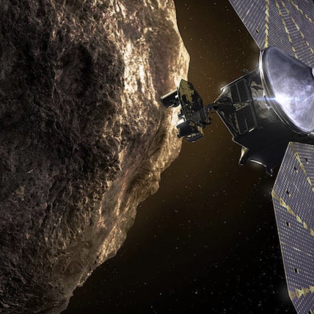 An artist's conception of the Lucy spacecraft inspecting a Trojan asteroid.